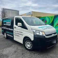 Sign-written black and white Toyota HiAce van