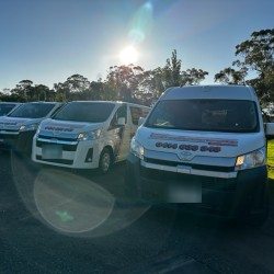 A fleet of white Toyota HiAce vans