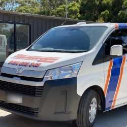 Sign-written white Toyota HiAce van