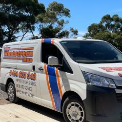 Sign-written white Toyota HiAce van, side view