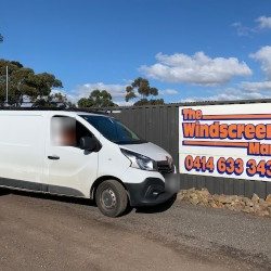White Renault Trafic van beside a business sign